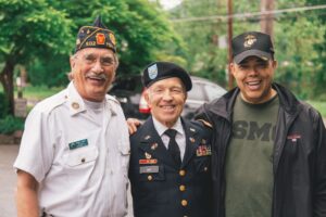 Three military veterans standing next to each other with their arms on each others shoulders