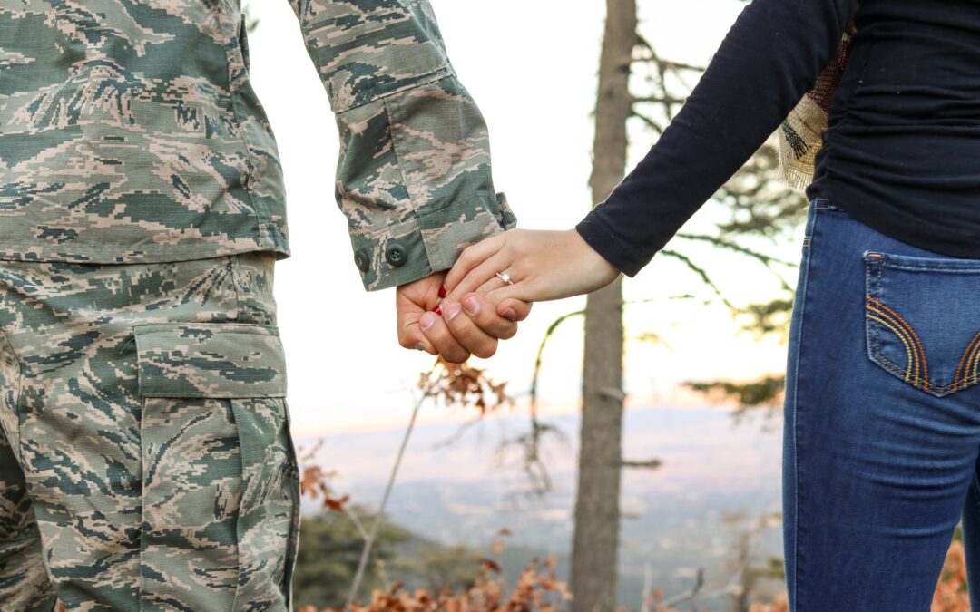 A soldier and his wife holding hands looking while looking into a valley